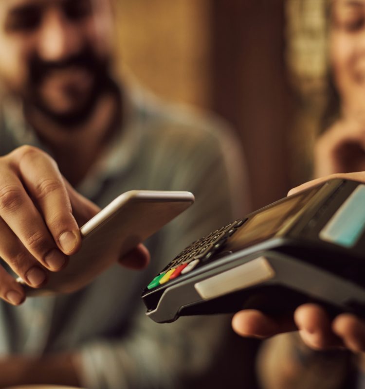 Close-up of man making contactless payment with smart phone. Close-up of man making contactless payment with smart phone.